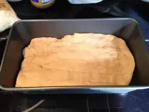 Press the dough into a greased loaf pan.